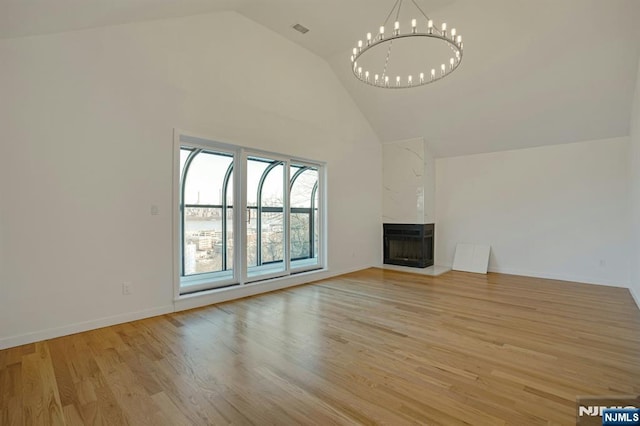 1 Columbus Pl, Cliffside Park, NJ 07010 - unfurnished living room featuring high vaulted ceiling, a fireplace, light wood finished floors, and a chandelier