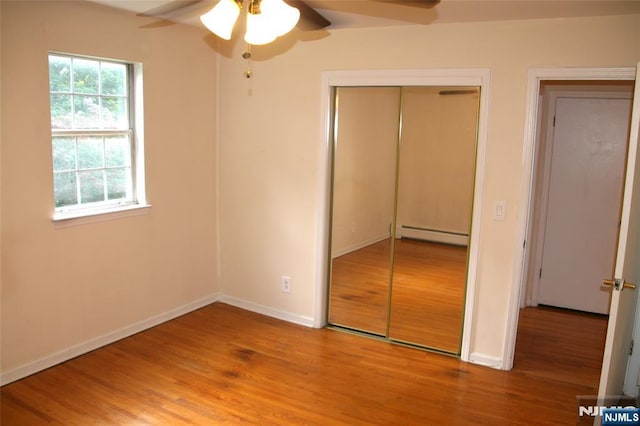 41 N Franklin Tpke Unit O, Ramsey, NJ 07446 - unfurnished bedroom with baseboard heating, a closet, wood finished floors, and multiple windows