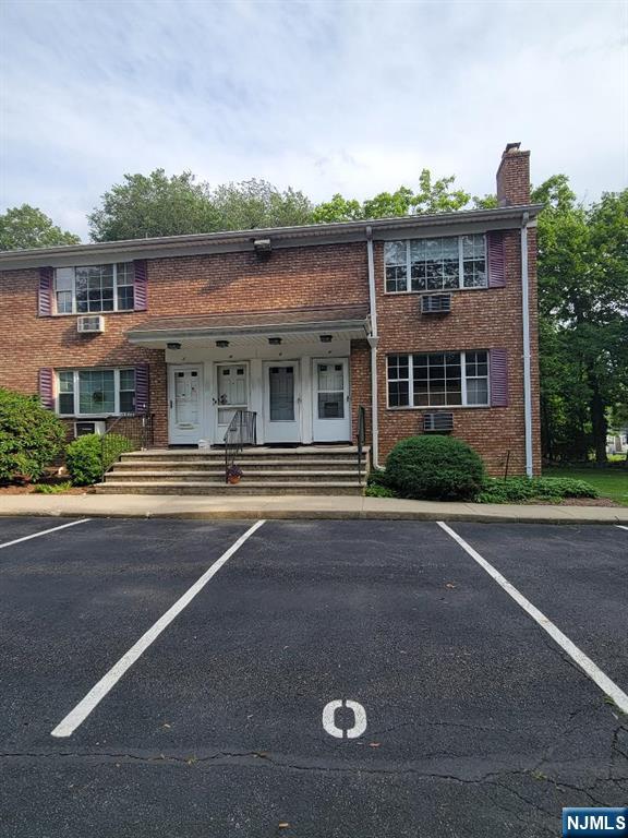 41 N Franklin Tpke Unit O, Ramsey, NJ 07446 - view of property featuring brick siding, a chimney, and uncovered parking