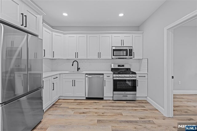 6 Pleasant Ave, Clifton, NJ 07013 - kitchen featuring stainless steel appliances, light countertops, white cabinets, light wood finished floors, and decorative backsplash