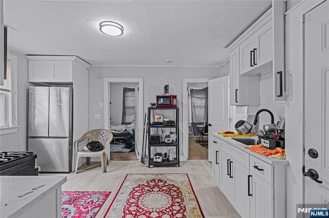 6 Pleasant Ave, Clifton, NJ 07013 - kitchen with freestanding refrigerator, white cabinets, light wood-type flooring, ornamental molding, and light stone countertops