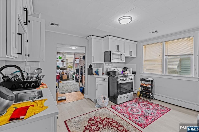 6 Pleasant Ave, Clifton, NJ 07013 - kitchen with stainless steel appliances, light wood-type flooring, light countertops, white cabinetry, and baseboard heating
