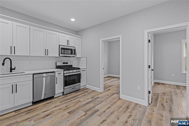 6 Pleasant Ave, Clifton, NJ 07013 - kitchen with appliances with stainless steel finishes, light countertops, tasteful backsplash, white cabinets, and recessed lighting