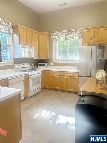 84 Pheasant Run Unit 84, Old Tappan, NJ 07675 - kitchen featuring white appliances, light countertops, and light brown cabinets