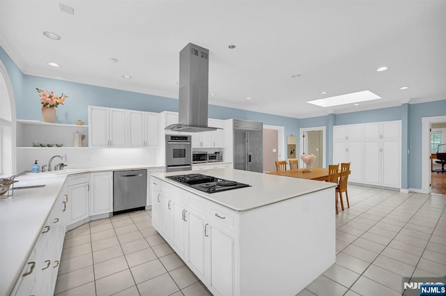 326 Ridge Rd, Cedar Grove, NJ 07009 - kitchen featuring appliances with stainless steel finishes, island exhaust hood, open shelves, light tile patterned flooring, and a skylight