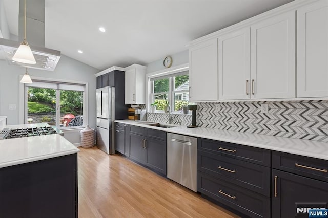 17 Lowell Ave, West Orange, NJ 07052 - kitchen with appliances with stainless steel finishes, white cabinetry, ventilation hood, light countertops, and light wood finished floors