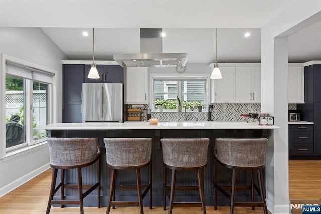 17 Lowell Ave, West Orange, NJ 07052 - kitchen with stainless steel fridge, wall chimney exhaust hood, backsplash, light countertops, and recessed lighting