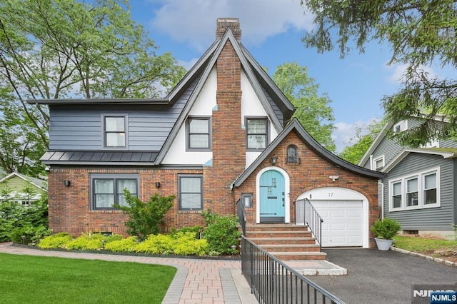 17 Lowell Ave, West Orange, NJ 07052 - english style home featuring brick siding, an attached garage, asphalt driveway, a standing seam roof, and a chimney