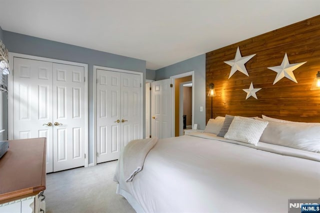 611 Maze Rd, River Vale, NJ 07675 - bedroom with two closets, wood walls, carpet floors, and an accent wall