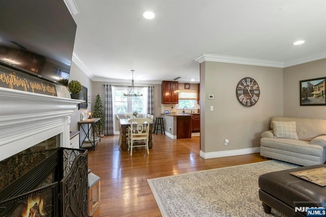 611 Maze Rd, River Vale, NJ 07675 - living area featuring light wood-style flooring, ornamental molding, recessed lighting, a fireplace, and a chandelier
