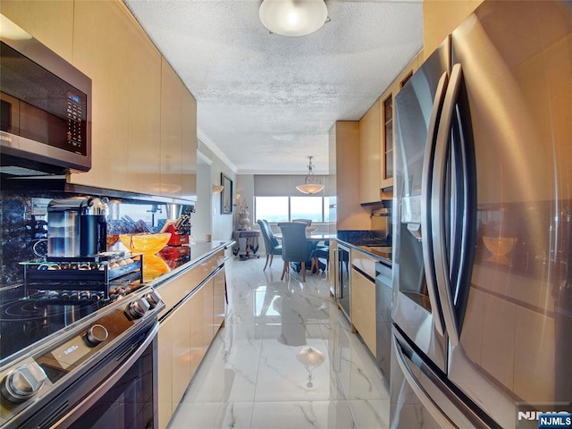 250 Gorge Rd Unit 23I, Cliffside Park, NJ 07010 - kitchen featuring appliances with stainless steel finishes, light marble finish floors, modern cabinets, a textured ceiling, and ornamental molding