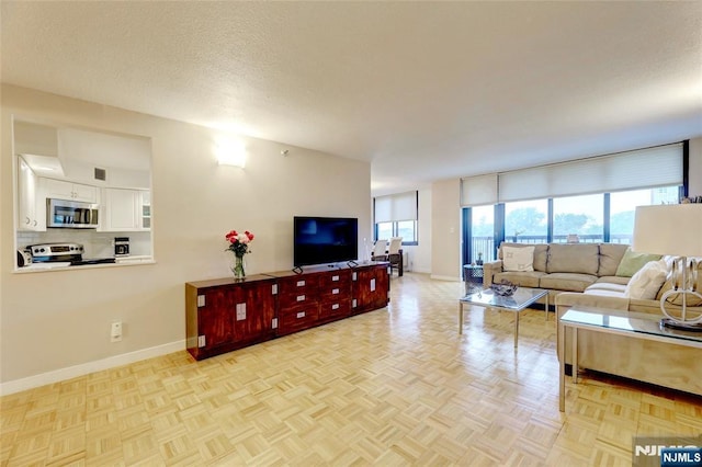 1265 15th St Unit 4C, Fort Lee, NJ 07024 - living room with baseboards and a textured ceiling