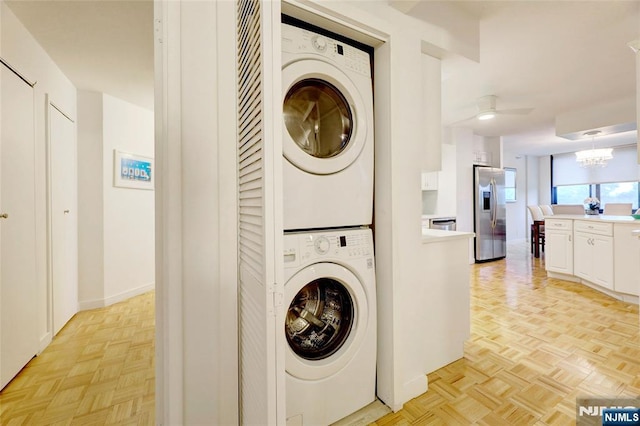 1265 15th St Unit 4C, Fort Lee, NJ 07024 - laundry area featuring stacked washing machine and dryer and a chandelier
