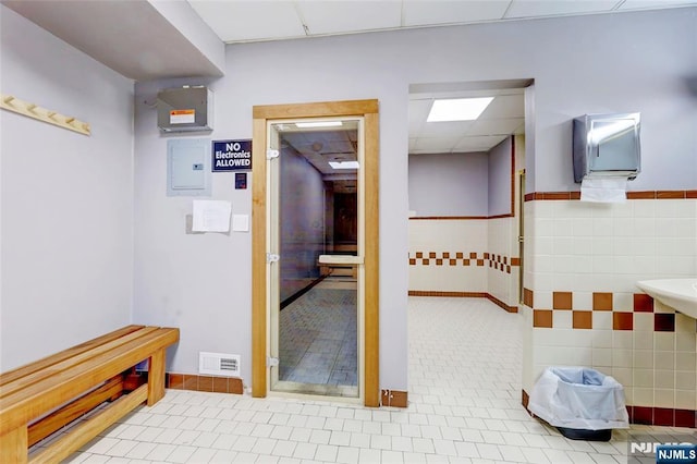 1265 15th St Unit 4C, Fort Lee, NJ 07024 - corridor featuring tile patterned flooring, tile walls, a drop ceiling, and wainscoting