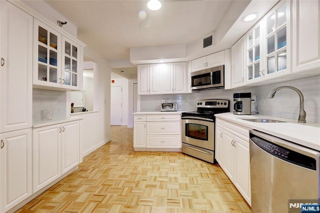 1265 15th St Unit 4C, Fort Lee, NJ 07024 - kitchen featuring appliances with stainless steel finishes, decorative backsplash, light countertops, and white cabinetry
