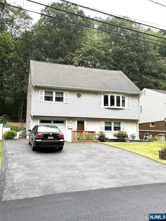 158 Woodhaven Dr, Wayne, NJ 07470 - view of front of house with driveway, a garage, a chimney, and a front yard