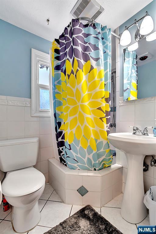 76 Hillside Rd, Sparta, NJ 07871 - bathroom featuring tile walls, tile patterned flooring, shower / bath combination with curtain, and wainscoting