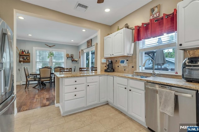 18 Gillies St, Clifton, NJ 07013 - kitchen with stainless steel appliances, a peninsula, ornamental molding, backsplash, and white cabinetry
