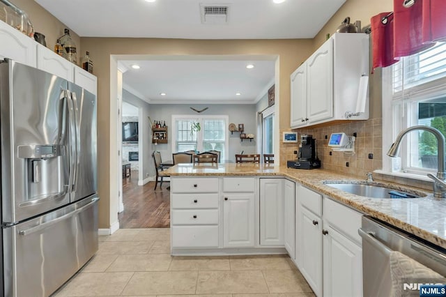 18 Gillies St, Clifton, NJ 07013 - kitchen with stainless steel appliances, a peninsula, light stone counters, white cabinets, and recessed lighting