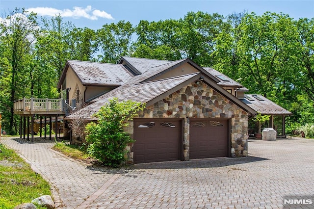 69 Mount Pleasant Rd, Knowlton, NJ 07832 - view of home's exterior featuring stone siding, decorative driveway, an attached garage, and a wooden deck