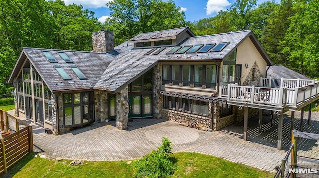 69 Mount Pleasant Rd, Knowlton, NJ 07832 - rear view of house with a sunroom, stone siding, a patio area, and a chimney