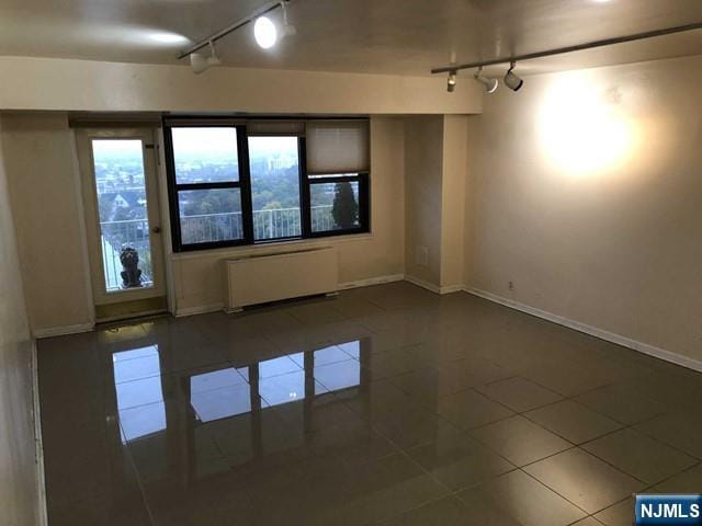 285 Aycrigg Ave Unit 22D, Passaic, NJ 07055 - tiled spare room featuring track lighting and radiator