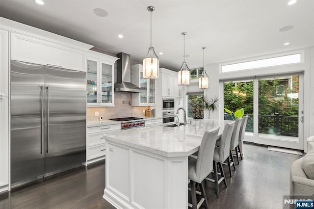 12 Hooks Ln, Edgewater, NJ 07020 - kitchen featuring appliances with stainless steel finishes, wall chimney exhaust hood, dark wood-style flooring, backsplash, and white cabinetry