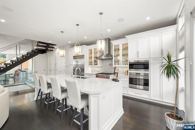 12 Hooks Ln, Edgewater, NJ 07020 - kitchen with stainless steel appliances, wall chimney exhaust hood, dark wood-style floors, white cabinets, and recessed lighting