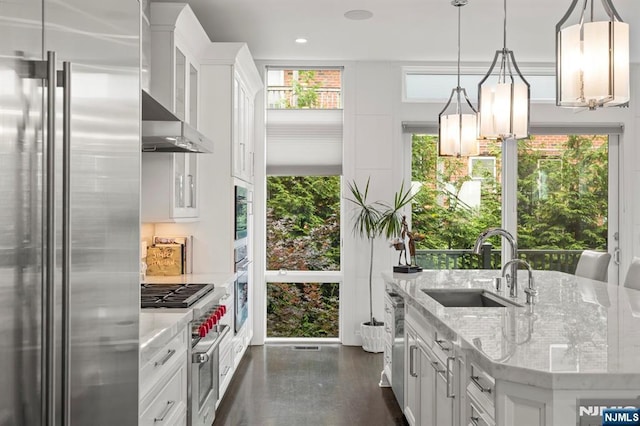 12 Hooks Ln, Edgewater, NJ 07020 - kitchen with high quality appliances, white cabinetry, light stone countertops, wall chimney exhaust hood, and pendant lighting