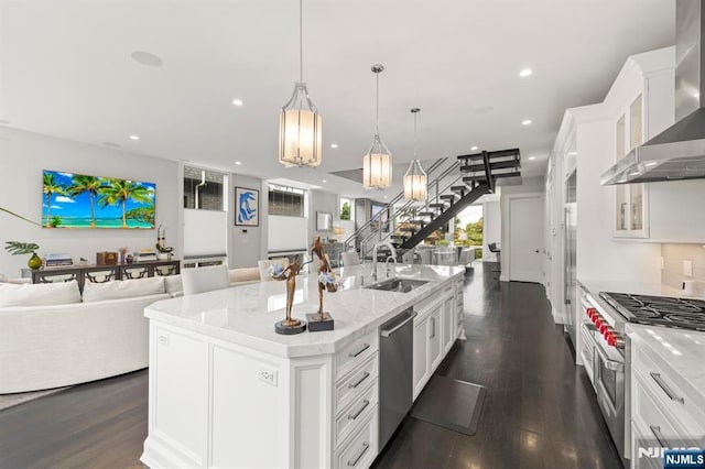 12 Hooks Ln, Edgewater, NJ 07020 - kitchen with appliances with stainless steel finishes, wall chimney range hood, open floor plan, dark wood-style flooring, and a spacious island