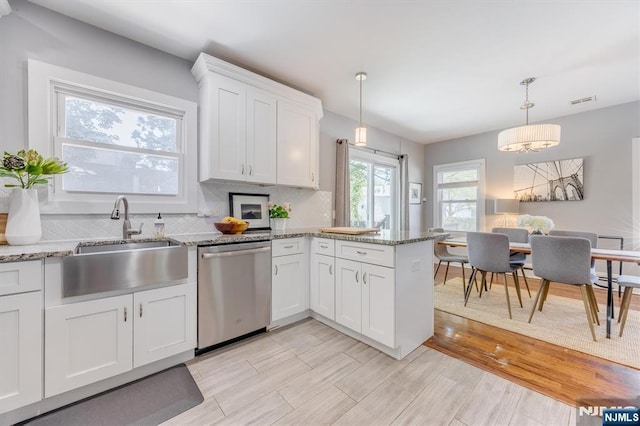 20 Brighton Ave, Bloomfield, NJ 07003 - kitchen featuring stainless steel dishwasher, white cabinetry, a peninsula, tasteful backsplash, and hanging light fixtures
