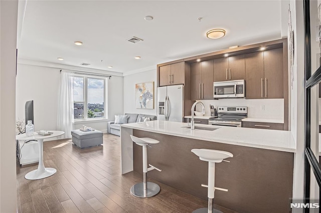 6401 Park Ave Unit 401, West New York, NJ 07093 - kitchen featuring appliances with stainless steel finishes, a kitchen breakfast bar, wood finished floors, crown molding, and open floor plan