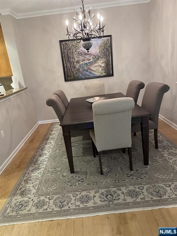 5 Cliff Rd Unit C1, Woodland Park, NJ 07424 - dining area with a chandelier, wood finished floors, and crown molding