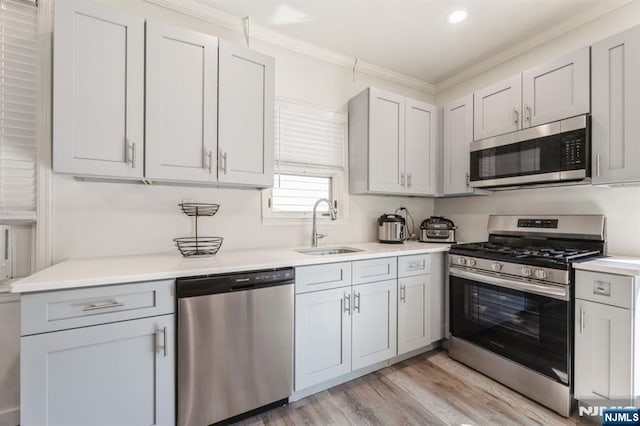 187 Wallington Ave, Wallington, NJ 07057 - kitchen featuring appliances with stainless steel finishes, crown molding, light countertops, light wood finished floors, and recessed lighting