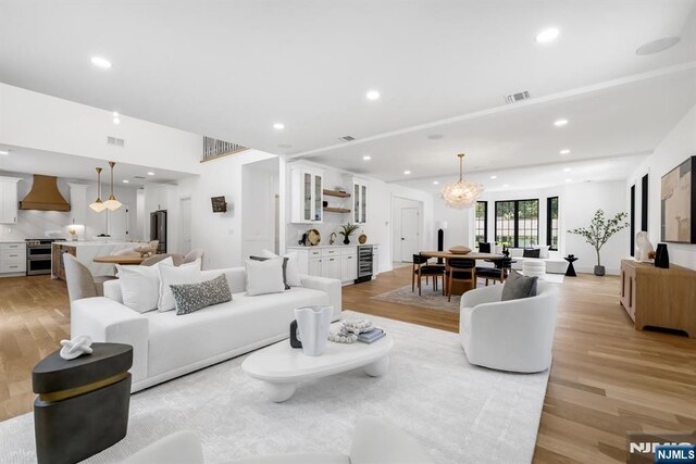 452 Oregon St, Paramus, NJ 07652 - living room with light wood-type flooring, recessed lighting, wine cooler, and a chandelier