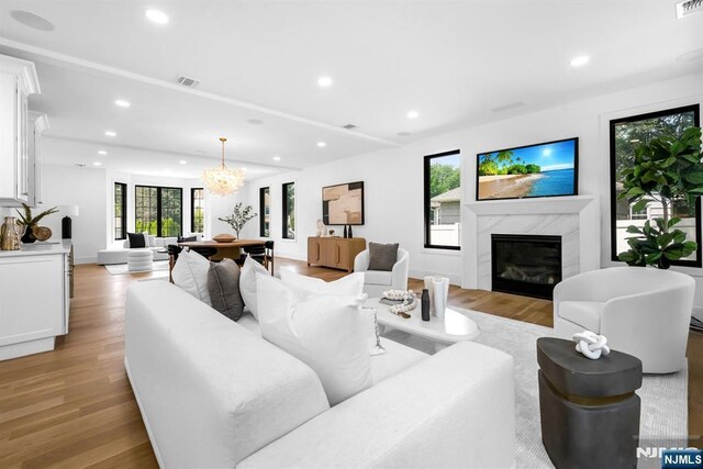 452 Oregon St, Paramus, NJ 07652 - living area featuring light wood finished floors, a high end fireplace, recessed lighting, and a chandelier