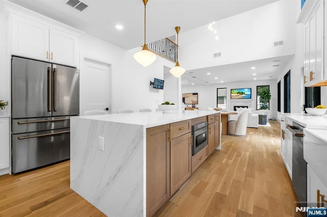 452 Oregon St, Paramus, NJ 07652 - kitchen featuring stainless steel appliances, light wood-style flooring, white cabinets, recessed lighting, and a high ceiling