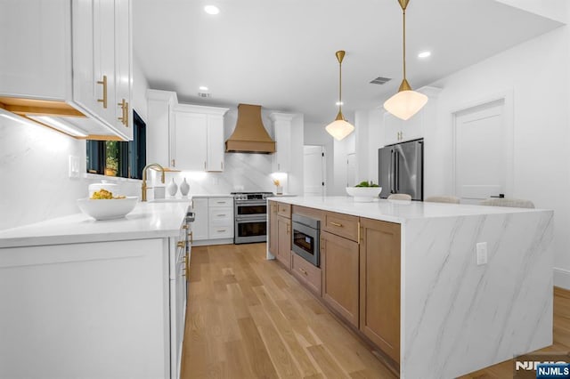 452 Oregon St, Paramus, NJ 07652 - kitchen with stainless steel appliances, premium range hood, white cabinets, a center island, and tasteful backsplash