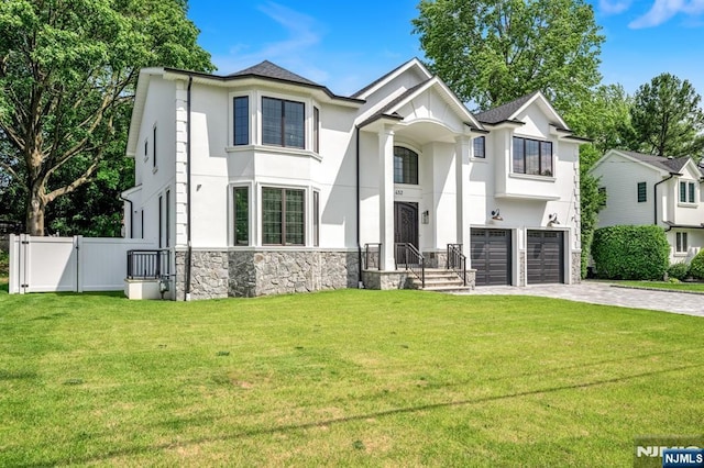 452 Oregon St, Paramus, NJ 07652 - view of front facade with stone siding, stucco siding, an attached garage, and decorative driveway