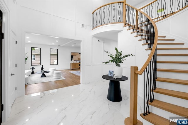 452 Oregon St, Paramus, NJ 07652 - staircase featuring a decorative wall, marble tiled floors, and a towering ceiling