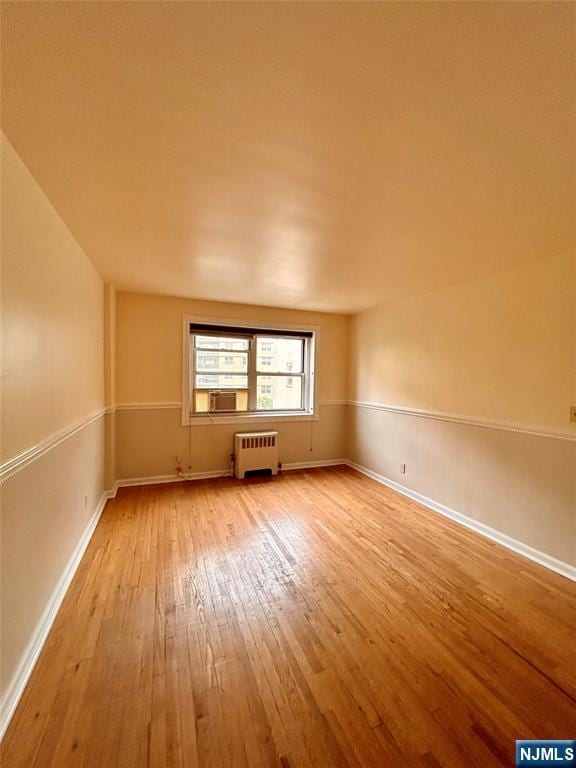 2195 N Central Rd Unit 4H, Fort Lee, NJ 07024 - empty room with radiator heating unit, light wood-style floors, and cooling unit