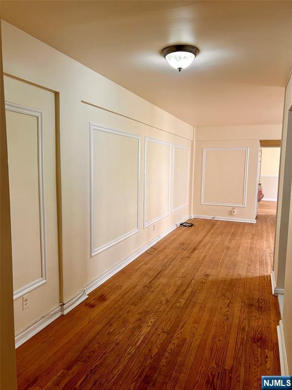 2195 N Central Rd Unit 4H, Fort Lee, NJ 07024 - corridor featuring wood finished floors and a decorative wall