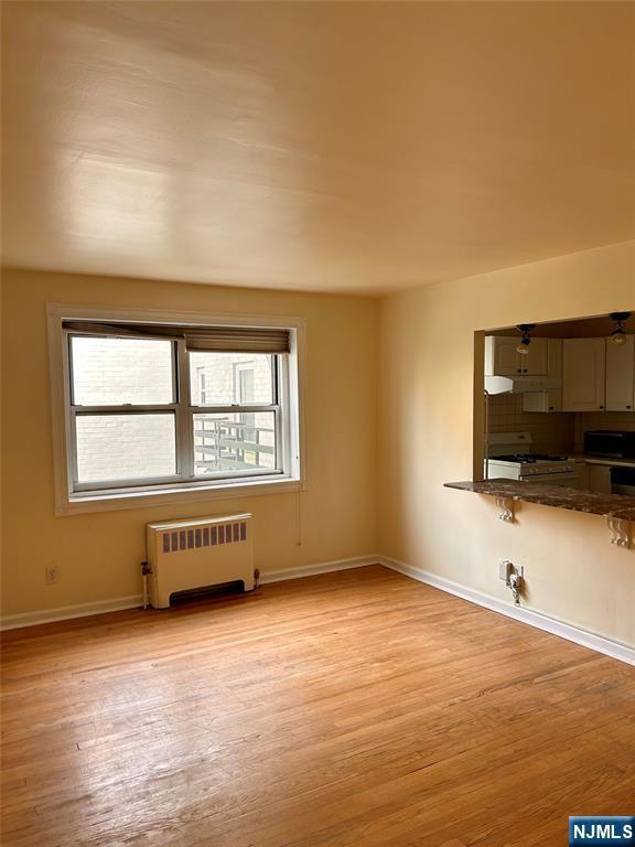 2195 N Central Rd Unit 4H, Fort Lee, NJ 07024 - empty room featuring radiator and light wood finished floors