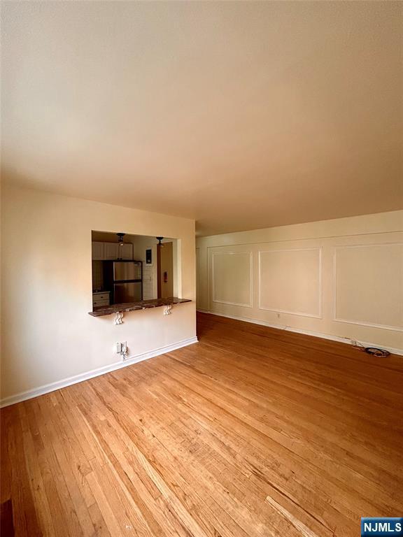 2195 N Central Rd Unit 4H, Fort Lee, NJ 07024 - unfurnished living room featuring light wood-style flooring and baseboards