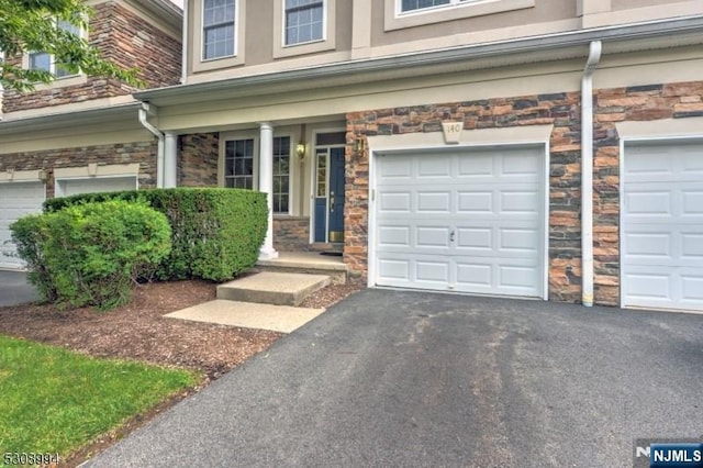 140 Levinberg Ln, Wayne, NJ 07470 - entrance to property with stone siding, driveway, a porch, and a garage
