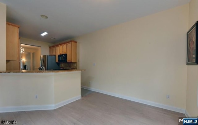 140 Levinberg Ln, Wayne, NJ 07470 - kitchen with freestanding refrigerator, black microwave, light wood-style floors, backsplash, and light brown cabinetry