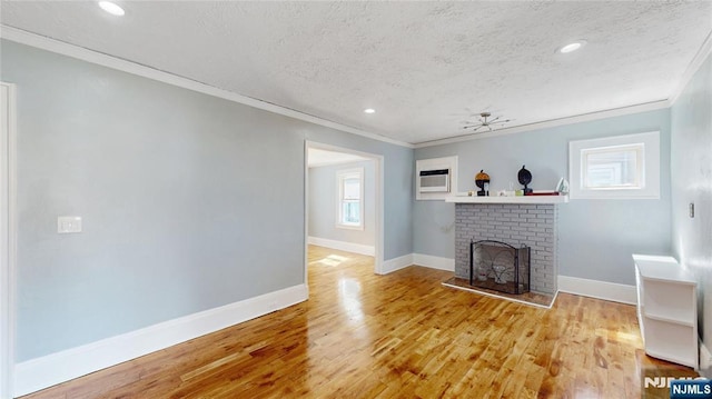 39 Boyden Pkwy, Maplewood, NJ 07040 - unfurnished living room featuring ornamental molding, a textured ceiling, a brick fireplace, wood finished floors, and an AC wall unit