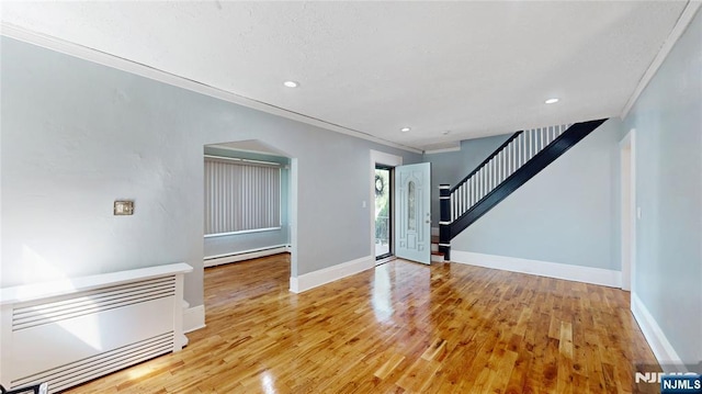 39 Boyden Pkwy, Maplewood, NJ 07040 - unfurnished room featuring a baseboard heating unit, crown molding, light wood finished floors, recessed lighting, and stairway