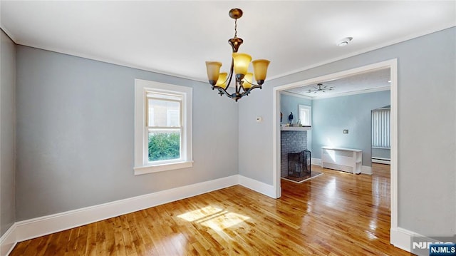 39 Boyden Pkwy, Maplewood, NJ 07040 - unfurnished dining area featuring a chandelier, a baseboard heating unit, light wood-style flooring, a fireplace, and crown molding