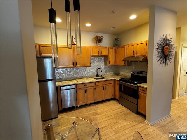 7206 Richmond Rd Unit 7206, West Milford, NJ 07480 - kitchen featuring appliances with stainless steel finishes, under cabinet range hood, light wood-type flooring, tasteful backsplash, and brown cabinetry